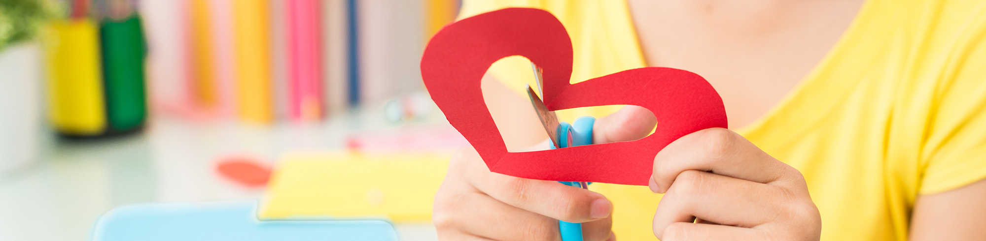 Student cutting out paper heart