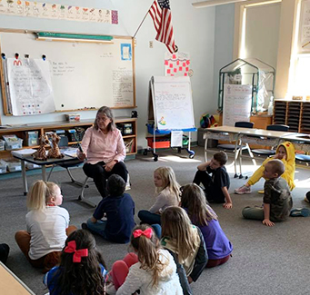 Teacher reading with her students in the classroom